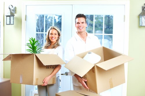 Local movers handling packed boxes on a residential Mortlake street